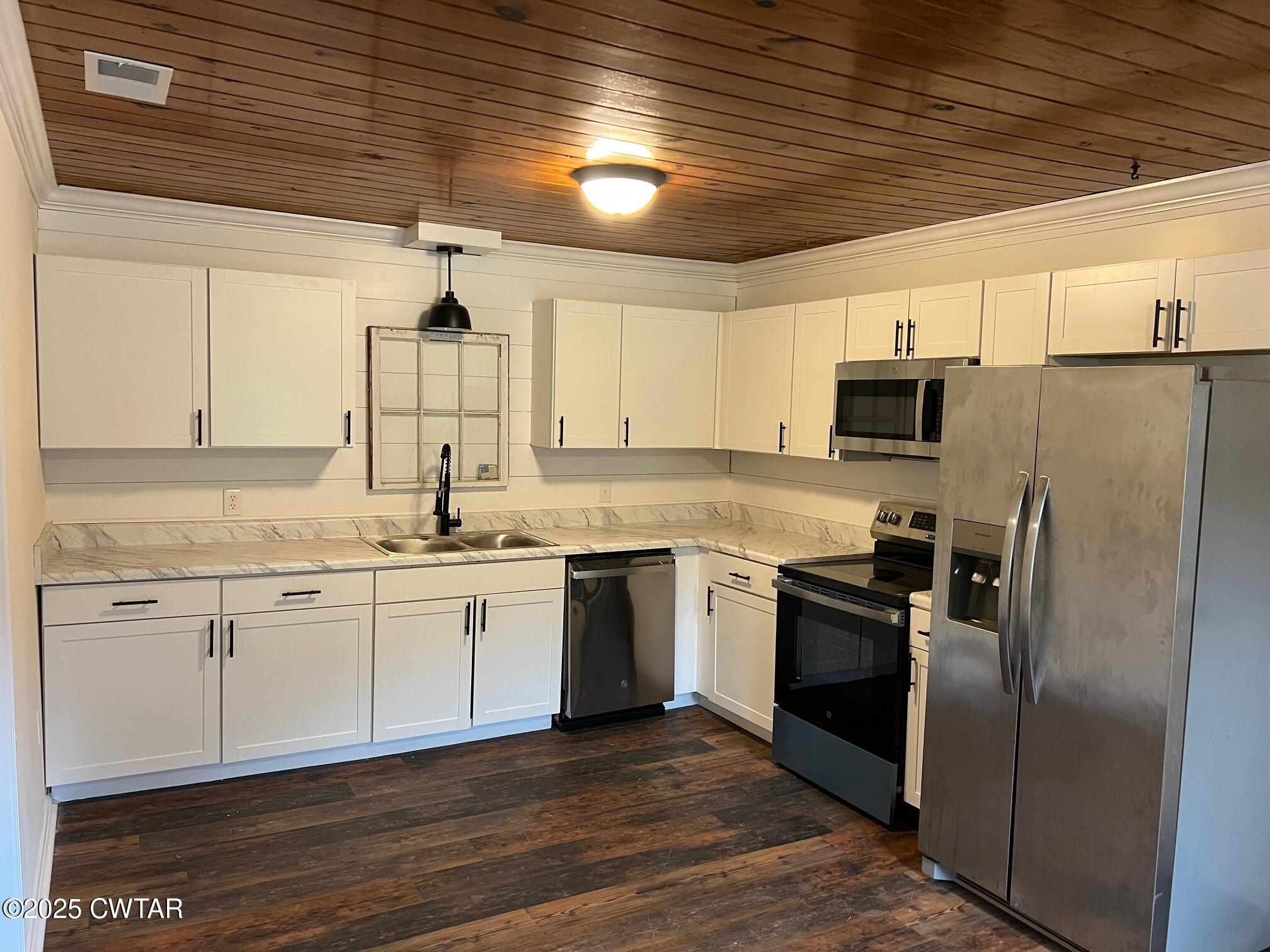 2215 Old Jacks Creek Road Henderson, TN 38340 - Photo 2 of 19 a kitchen with stainless steel appliances granite countertop a refrigerator a sink dishwasher a stove and white countertops with wooden floor