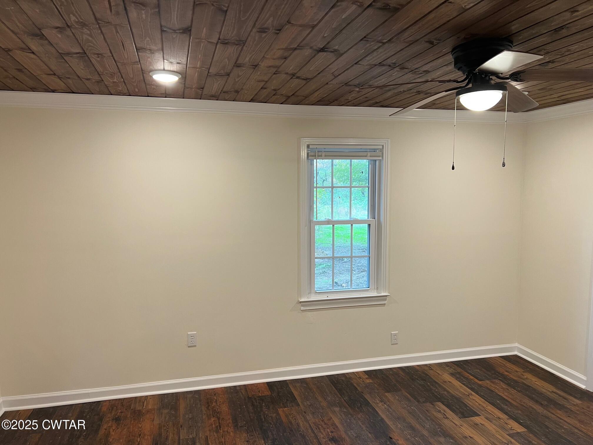 2215 Old Jacks Creek Road Henderson, TN 38340 - Photo 9 of 19 an empty room with wooden floor and windows