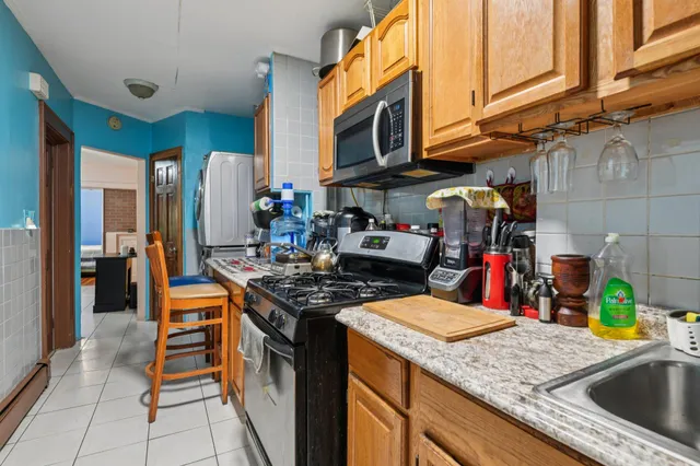 a kitchen with stainless steel appliances granite countertop a sink a stove and a wooden cabinets