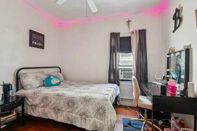 a bedroom with a bed a dresser and flat screen tv