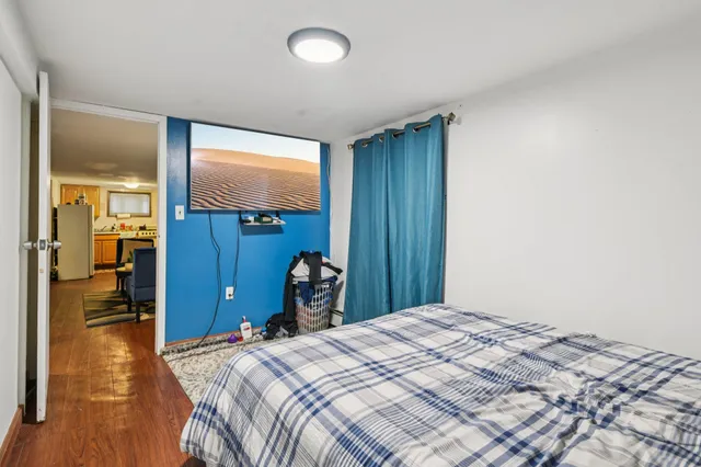 a bedroom with a bed and wooden floor