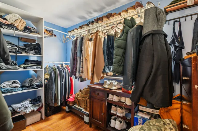 a view of walk in closet with clothes and shoes