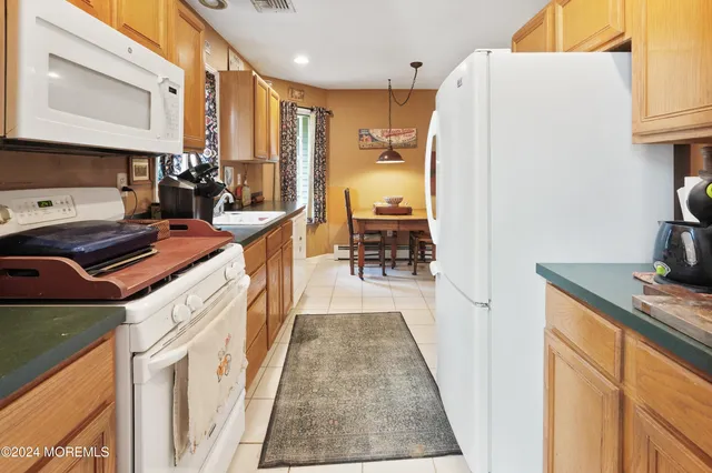 a kitchen with stainless steel appliances granite countertop a refrigerator a stove and a sink with wooden floor