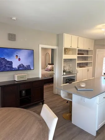 a living room with couches and kitchen view with wooden floor