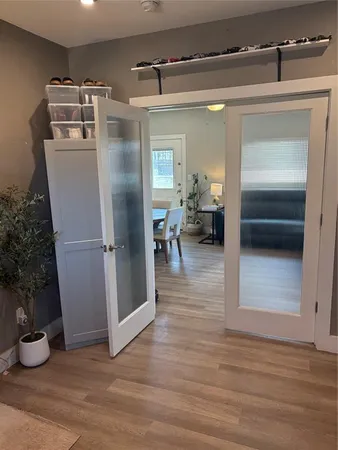a walk in closet with wooden floor