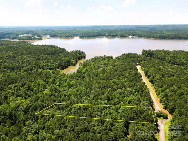 an aerial view of residential houses with outdoor space and lake view