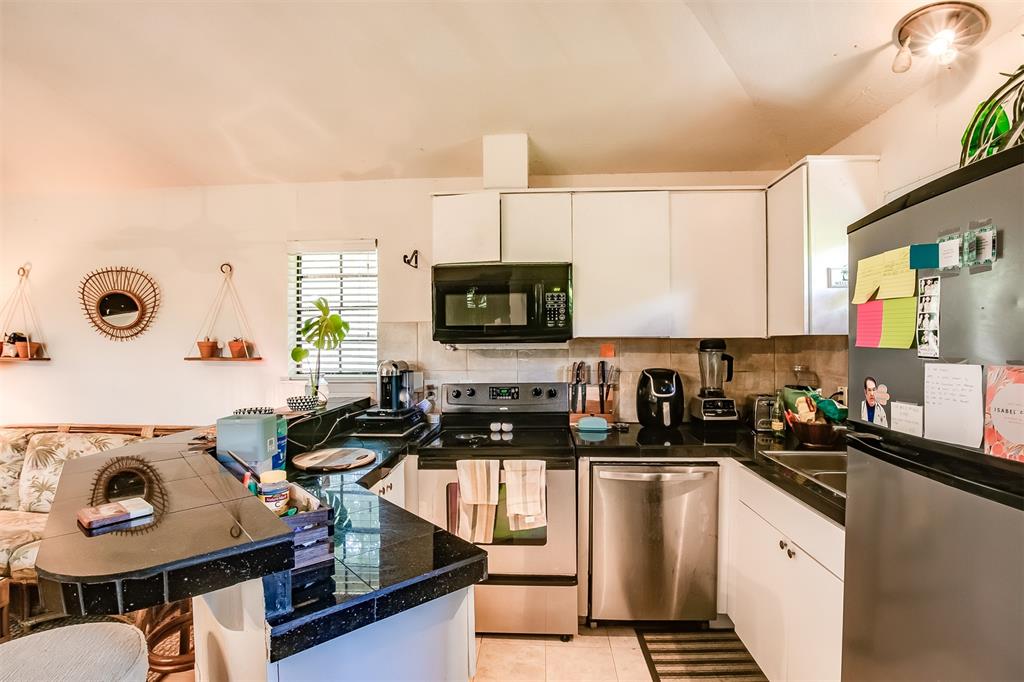 2400 Thornton Road, Unit A Austin, TX 78704 - Photo 6 of 13 Kitchen with stainless steel appliances, a breakfast bar area, white cabinetry, and a peninsula