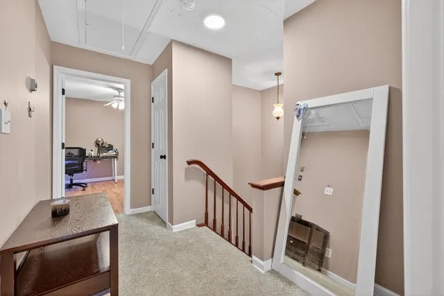 a view of a hallway to a livingroom with wooden floor and furniture