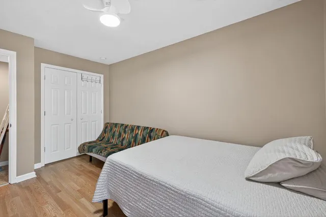 a bedroom with a bed and wooden floor