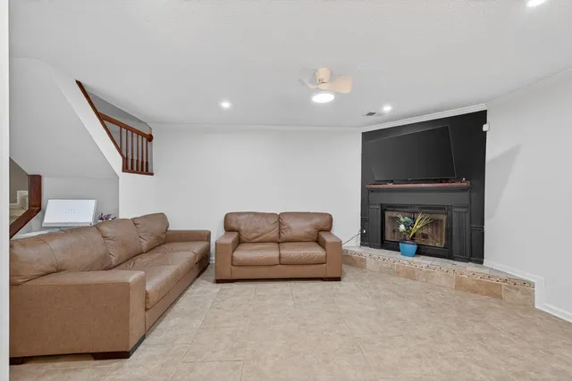 a living room with furniture a fireplace and a flat screen tv