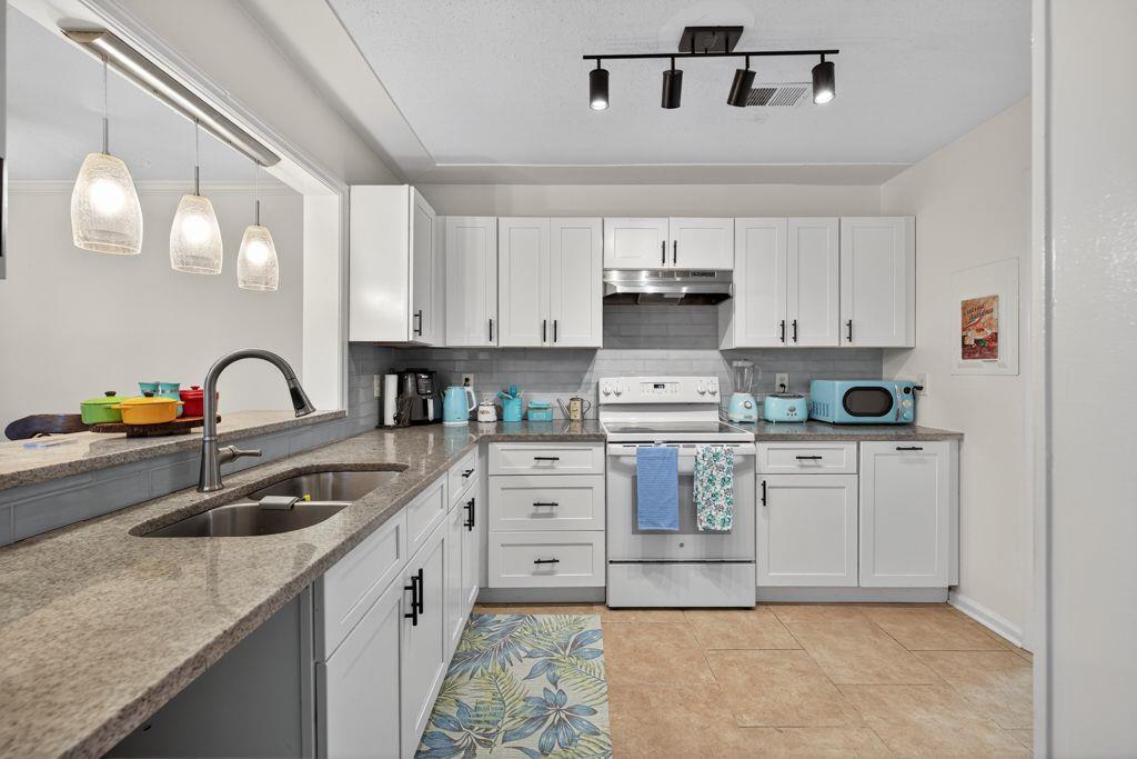 5970 WinterGreen Road Northwest Norcross, GA 30093 - Photo 10 of 34 a kitchen with white cabinets a sink and appliances