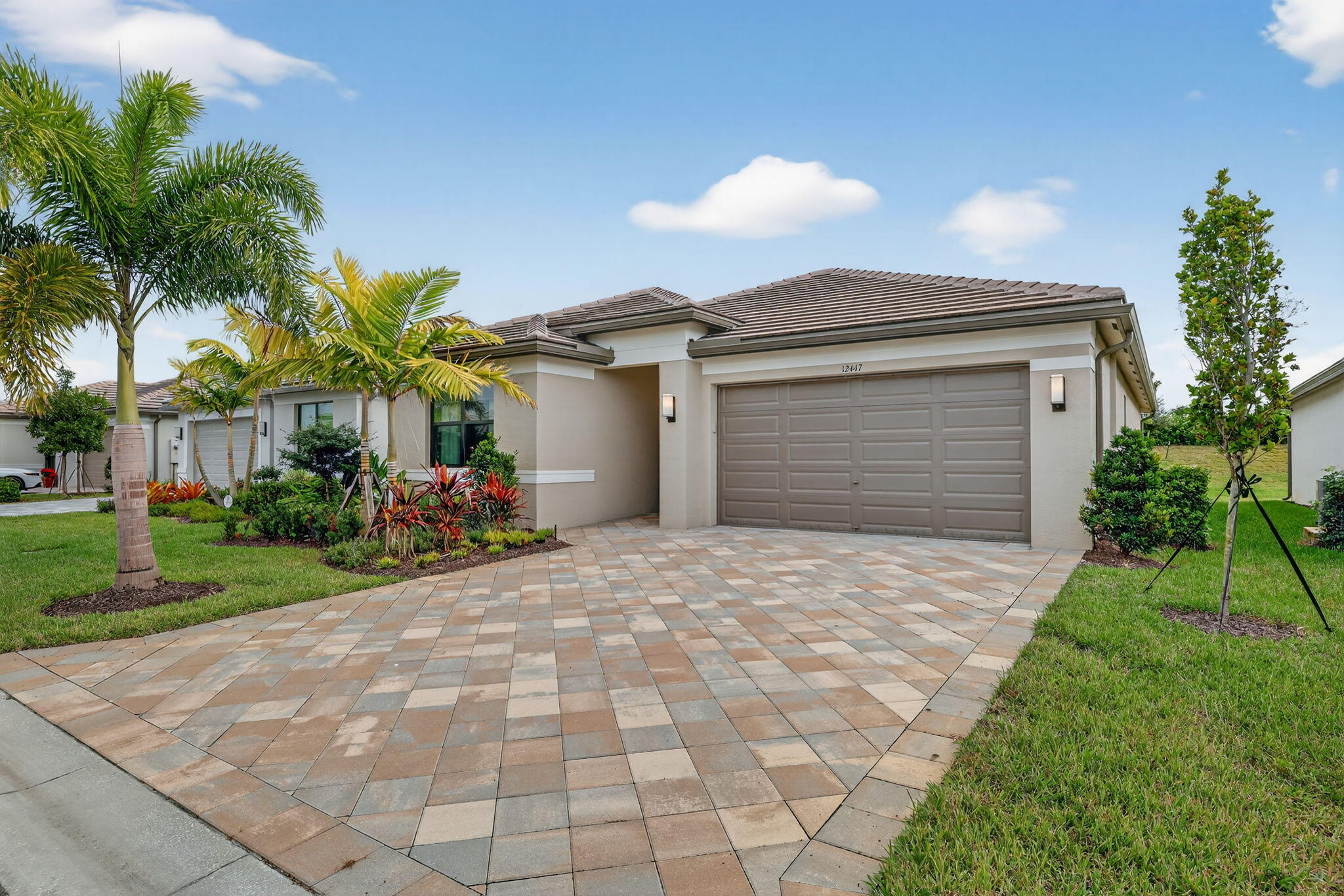 12447 Southwest Blue Mangrove Parkway Port St. Lucie, FL 34987 - Photo 2 of 80 a front view of a house with a yard and a garage