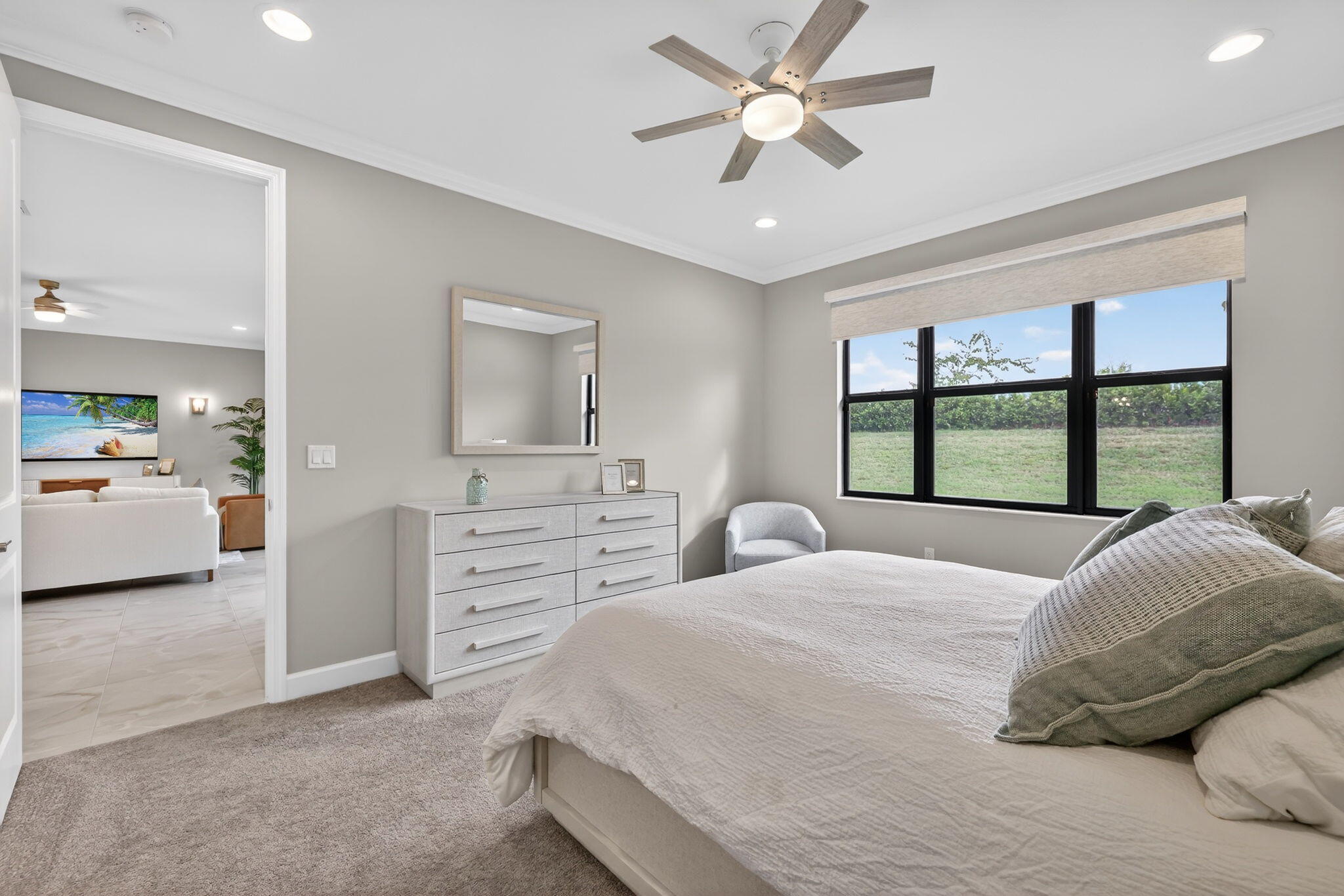 12447 Southwest Blue Mangrove Parkway Port St. Lucie, FL 34987 - Photo 22 of 80 a spacious bedroom with a large bed and a chandelier