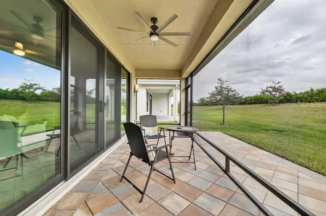 a view of a white house with a yard and potted plants