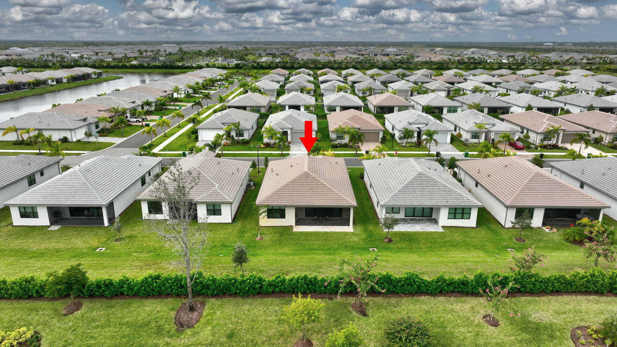 12447 Southwest Blue Mangrove Parkway Port St. Lucie, FL 34987 - Photo 41 of 80 a view of a white house with a yard and potted plants