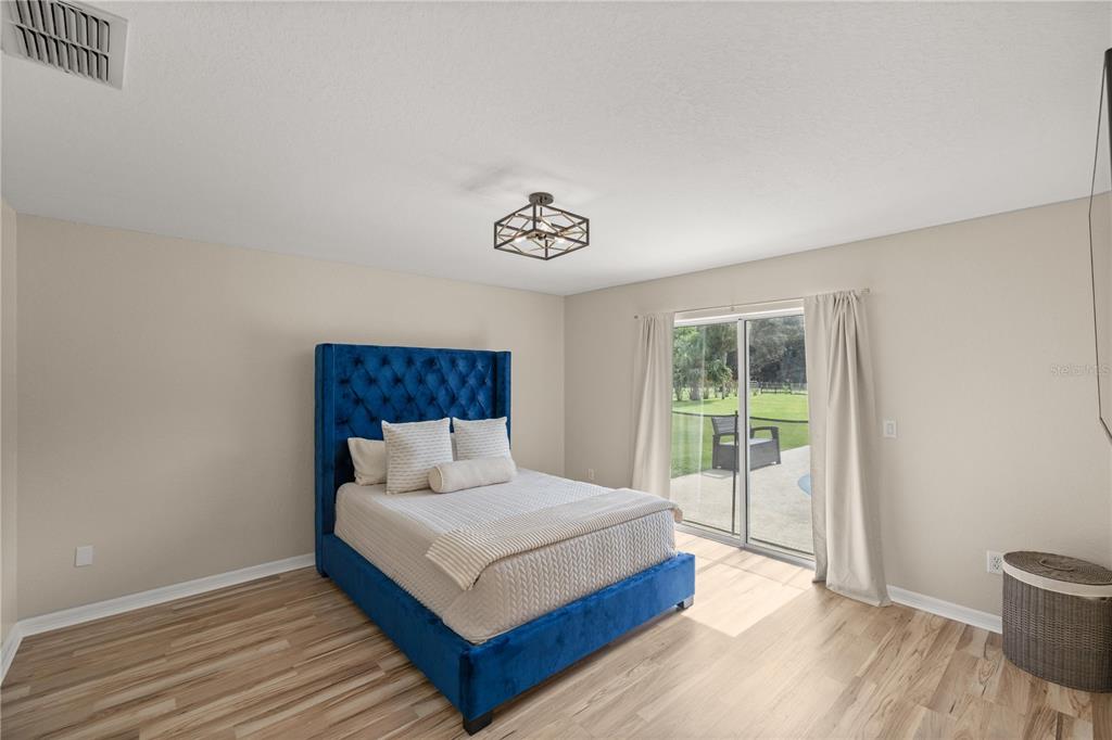 13783 Southeast 8th Court Ocala, FL 34480 - Photo 36 of 47 a bedroom with a bed lamp and a window