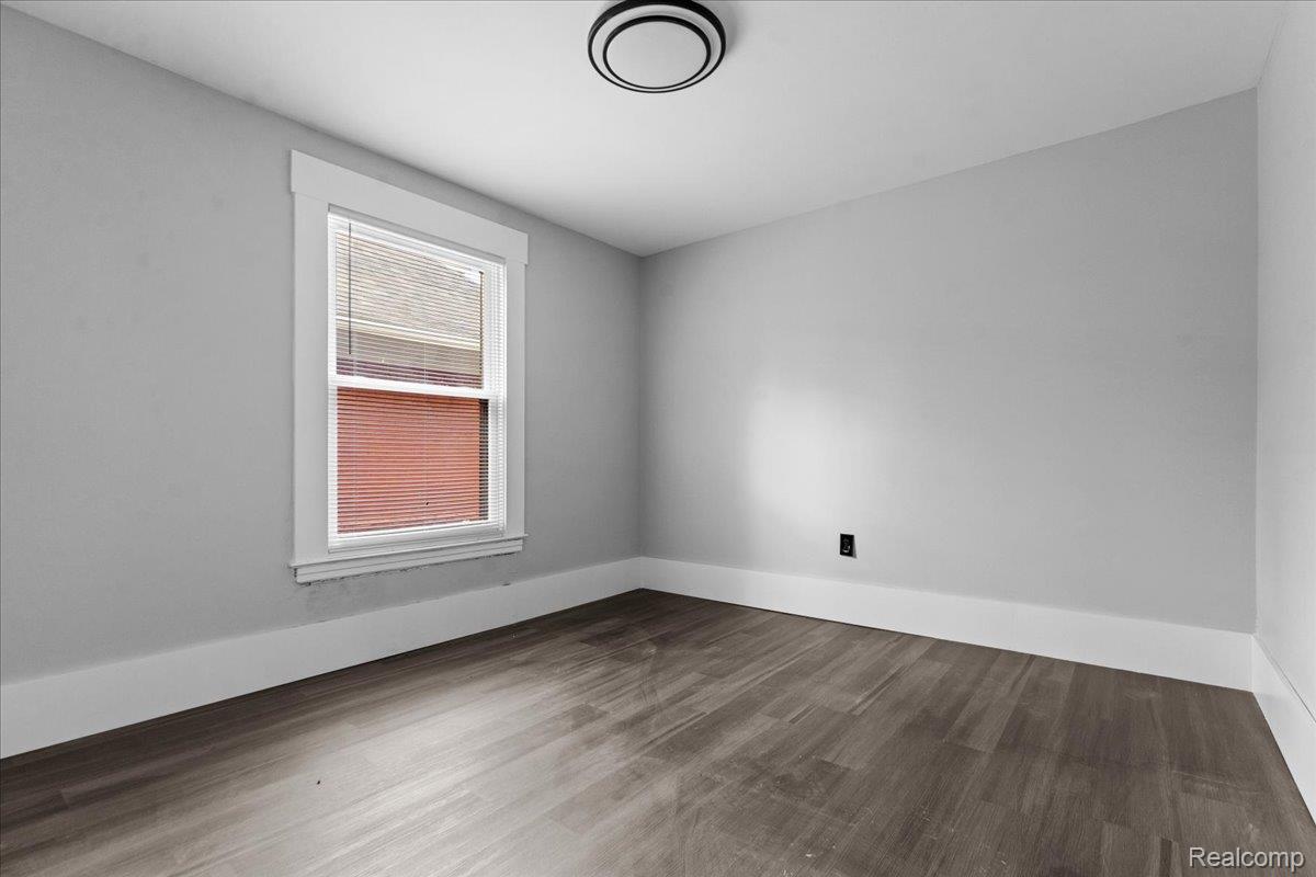 58 East Philadelphia Street Detroit, MI 48202 - Photo 17 of 24 Room featuring wood-finish flooring, light grey walls, and a white-trimmed window with blinds