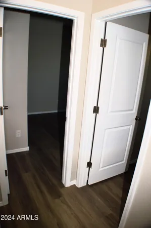a view of an empty room with wooden floor and cabinet