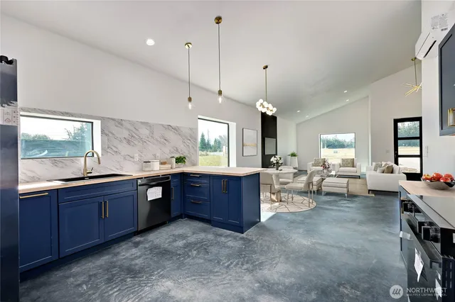a living room with stainless steel appliances granite countertop sink stove and wooden floor