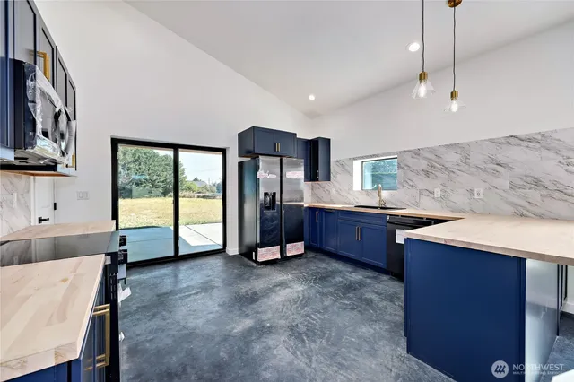 a large kitchen with stainless steel appliances granite countertop a sink and a stove