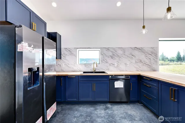 a kitchen with stainless steel appliances granite countertop a sink and wooden cabinets