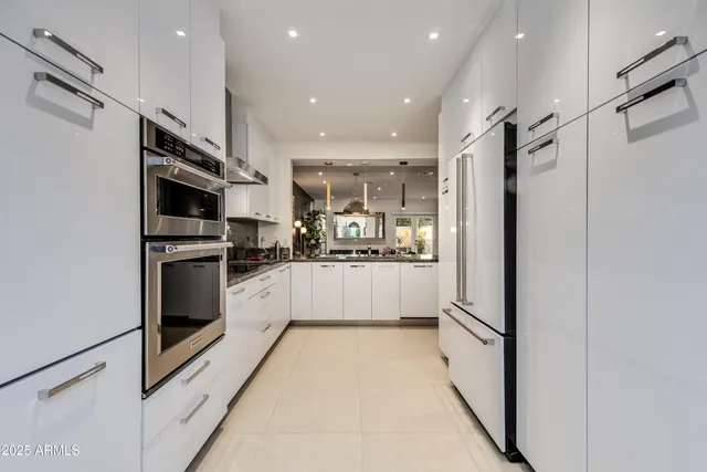 a kitchen with stainless steel appliances kitchen island granite countertop a stove a sink a dining table and chairs