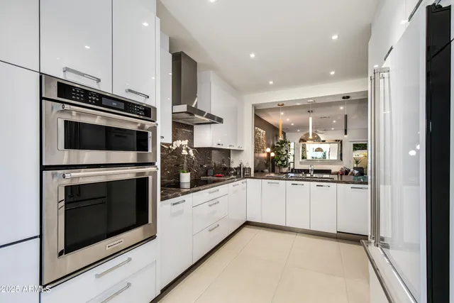 a kitchen with stainless steel appliances granite countertop a refrigerator and a sink