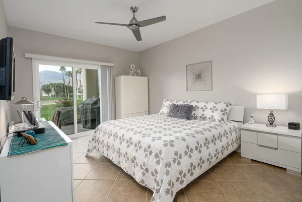 a bedroom with a bed a couch and a large window