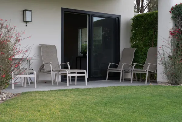 a view of a chairs and table in backyard