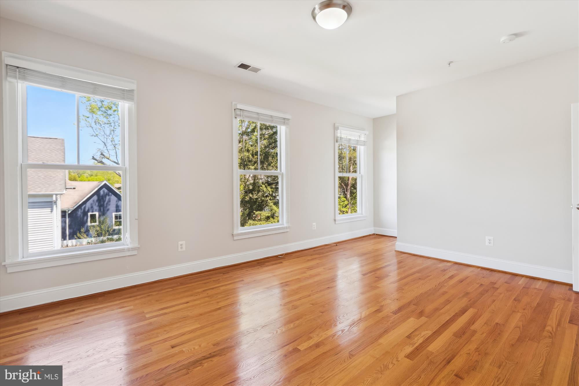 229 Locust Street Southeast, Unit 3 Vienna, VA 22180 - Photo 26 of 57 an empty room with wooden floor and windows