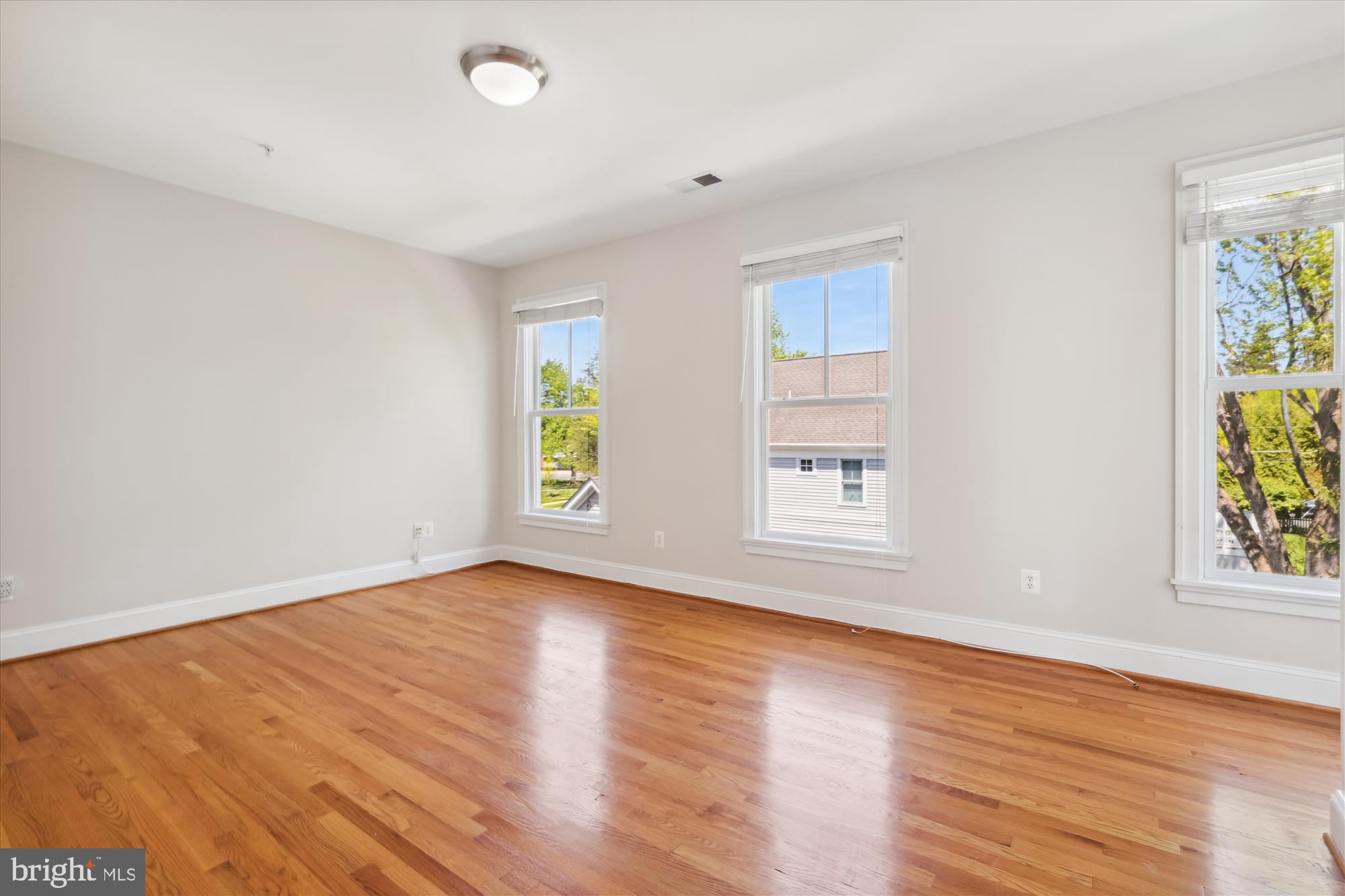 229 Locust Street Southeast, Unit 3 Vienna, VA 22180 - Photo 29 of 57 an empty room with window and wooden floor
