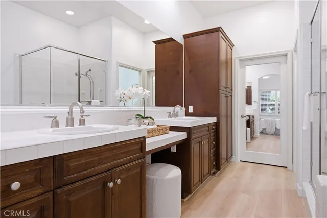 a spacious bathroom with a double vanity sink a mirror and a shower