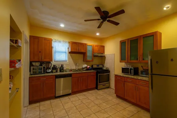 a kitchen with granite countertop a sink stainless steel appliances and cabinets