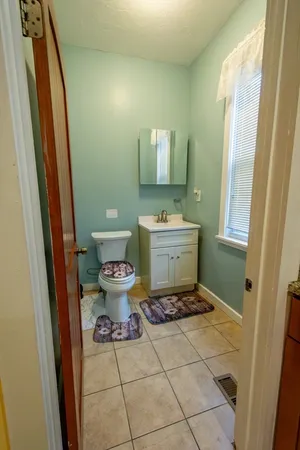 a bathroom with a toilet sink and mirror