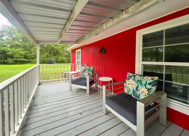 a view of a deck with couches table and chairs with wooden floor and fence