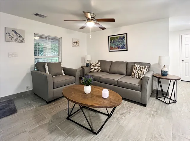 a living room with furniture a desk and chair with wooden floor
