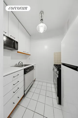 a kitchen with stainless steel appliances white cabinets and a stove top oven