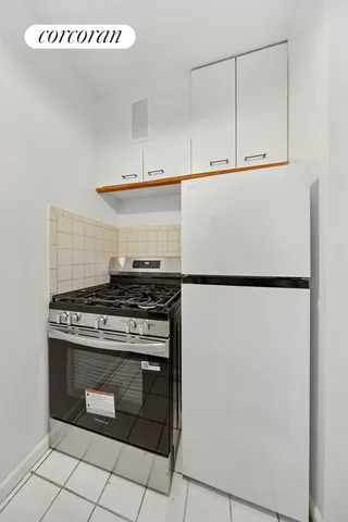 a kitchen with granite countertop white cabinets and white appliances