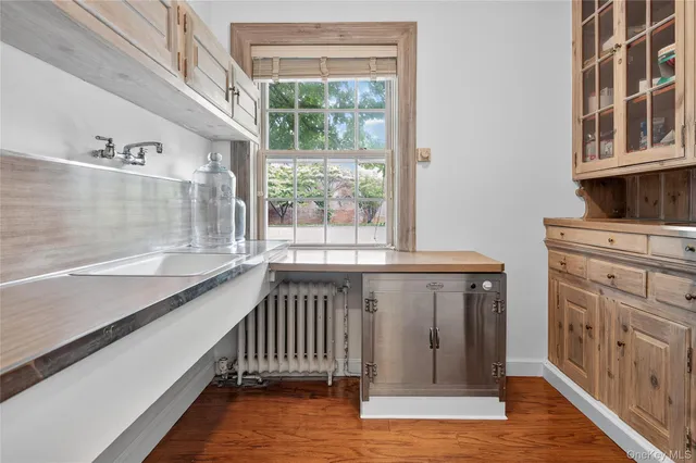 a view of a kitchen with wooden floor and electronic appliances