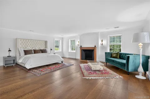 a bedroom with a bed a couch and a fireplace