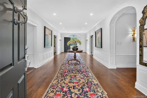 a view of a hallway with furniture and wooden floor
