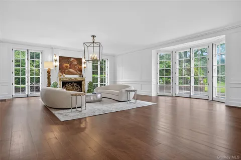 a living room with fireplace furniture and a large window