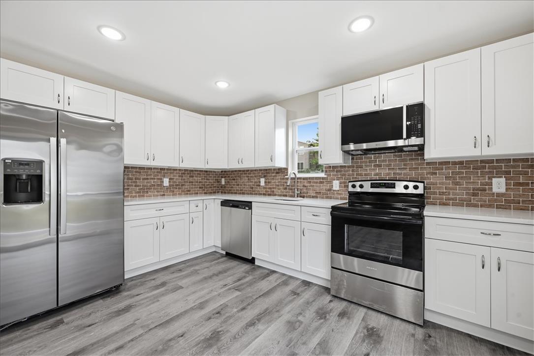 5641 North Coplay Road Whitehall, PA 18052 - Photo 5 of 68 A well-lit culinary space features bright cabinetry, stainless steel appliances, and wood-look flooring.