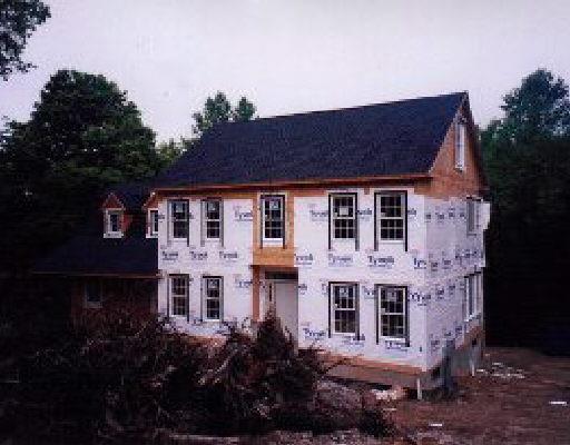 a view of a brick house with many windows and a yard