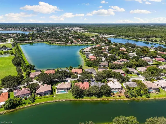 an aerial view of residential houses with outdoor space and lake view