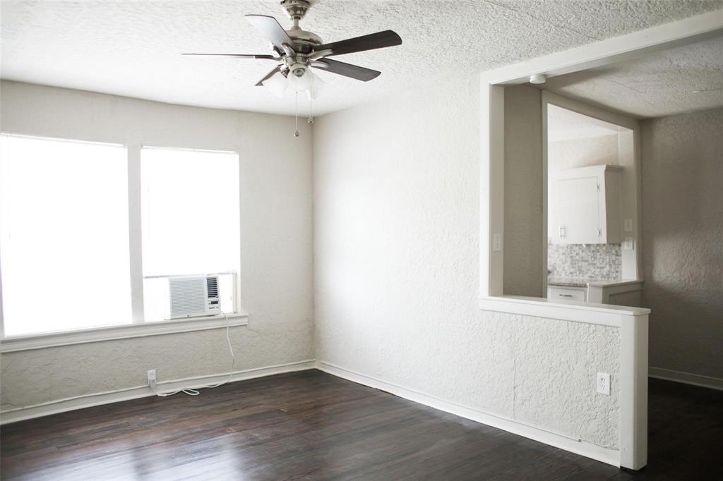 4107 Herschel Avenue, Unit 9 Dallas, TX 75219 - Photo 4 of 9 an empty room with wooden floor fan and windows