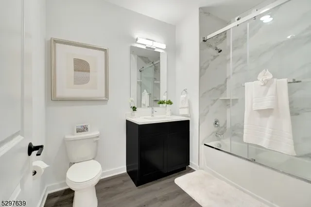 a bathroom with a sink toilet a mirror and shower