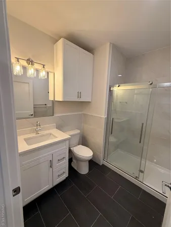 a bathroom with a sink a toilet a shower and a mirror