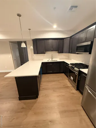 a kitchen with a sink and wooden floor