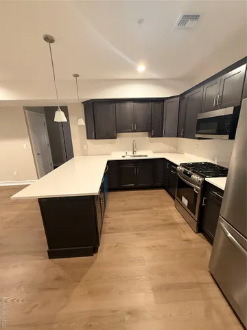 a kitchen with a sink and wooden floor